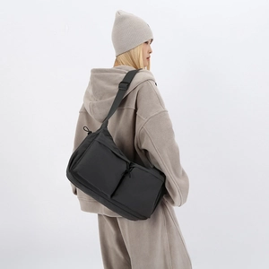 Dettaglio borsa a tracolla in nylon nero capiente con tasche multiple per uomo sport