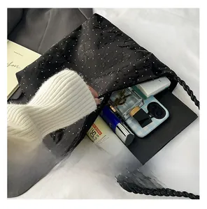 Interior view showing capacity of black polka dot hobo bag with cosmetics and phone