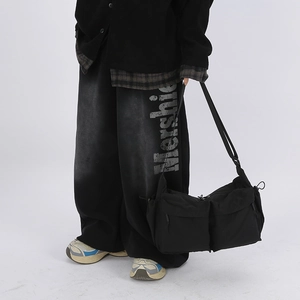 Dettaglio della borsa a tracolla in nylon nero impermeabile con doppie tasche e cinghie
