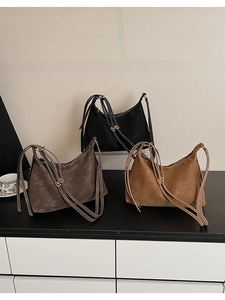 Three minimalist faux leather hobo bags in black, coffee, and tan colors on a desk