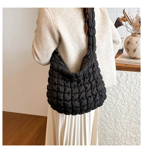 Detail der schwarzen gesteppten Shopper-Tasche mit Wolken-Struktur und breitem Gurt
