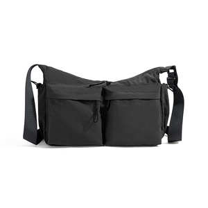 Dettaglio della borsa a tracolla in nylon nero con grandi tasche frontali a zip