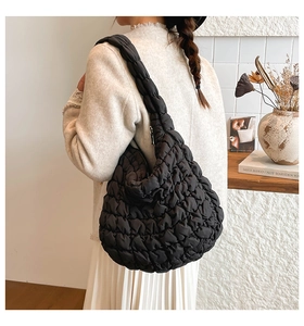 Detail der schwarzen Stepptasche mit Plissee-Struktur und weichem Puffergriff