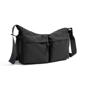 Dettaglio della borsa a tracolla tattica nera con tasche multiple e tessuto nylon