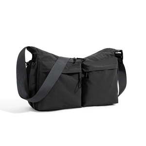 Dettaglio della borsa a tracolla in nylon nero con tasche multiple con cerniera