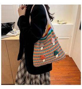 Detail of colorful rainbow crochet tote bag with unique 3D mushroom patches and wide strap