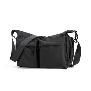 Dettaglio frontale della borsa a tracolla utility nera con ampie tasche e zip in nylon