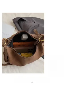 Top view of spacious brown shoulder bag interior showing daily essentials and storage