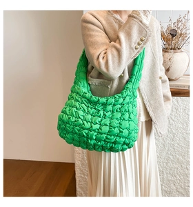 Detalle del bolso de nube acolchado verde con pliegues texturizados en modelo