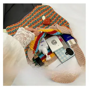 Macro view of a colorful handmade crochet bag showing internal storage for cosmetics