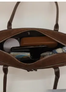 Interior view of brown suede handbag showing daily storage capacity for accessories