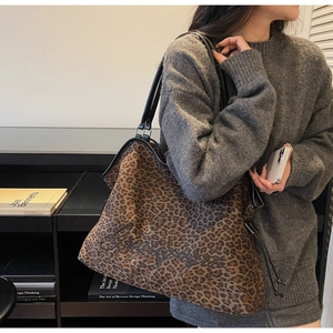 Detail of leopard print tote bag with black leather shoulder straps and letter embroidery