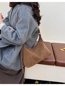 Brown suede shoulder bag with long strap shown in an autumn fashion street style