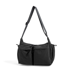 Vista dettagliata della borsa a tracolla nera con grandi tasche e dettagli con coulisse