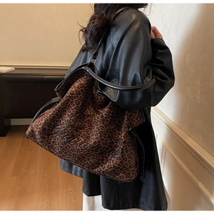 Detail view of stylish leopard print tote bag with black embroidery and leather straps