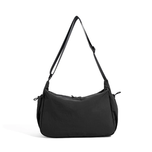 Dettaglio borsa a tracolla in nylon nero con coulisse laterale e cinturino regolabile