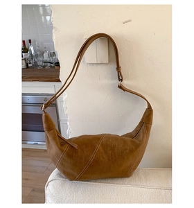 Detail of vintage brown crescent bag with white contrast stitching and adjustable strap