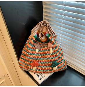 Detailed view of colorful striped crochet tote bag with 3D mushroom patches in soft sunlight