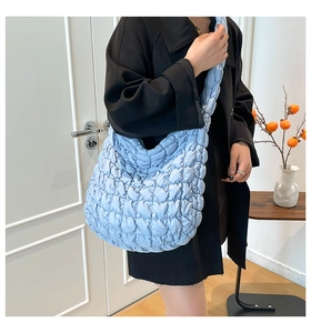 Detalle del bolso tote acolchado azul claro con textura de rejilla suave y mullida