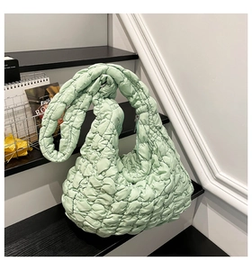 Detail der mintgrünen gesteppten Cloud-Tasche mit weicher Wattierung und Knotengriff