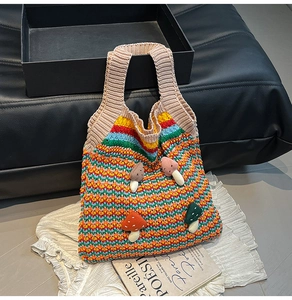 Detail of colorful knitted tote bag featuring 3D mushroom patches on wavy texture