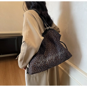 Detail of large leopard print hobo bag showing stylish fabric texture and black straps