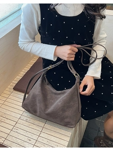 Close-up of a vintage brown matte hobo bag featuring a crescent shape and adjustable strap