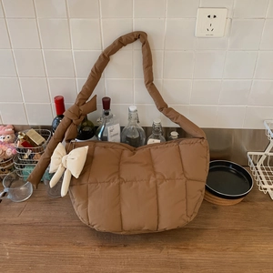 Vue détaillée du sac à bandoulière matelassé marron avec un grand nœud décoratif crème