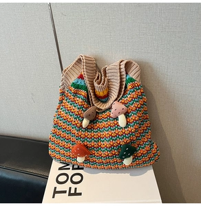 Detailed knit texture and plush mushroom patches on this colorful striped tote bag