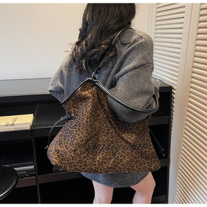 Detail of leopard print tote bag with black leather trim and custom embroidery on the side