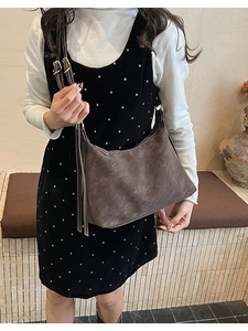 Detail of brown hobo bag with contrast white stitching and adjustable strap