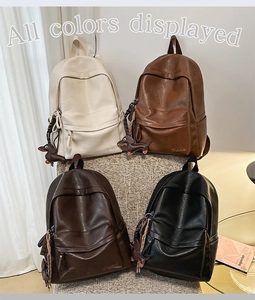 Quatre sacs à dos vintage en similicuir en ivoire, marron, café et noir sur une chaise