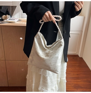 Detail of white satin shoulder bag with butterfly print, sequins and braided handle