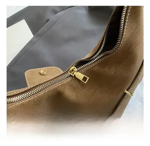 Detail of the high-quality gold zipper and textured brown leather on the tote bag