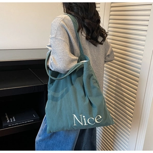 Detailed texture of dark green corduroy tote bag with Nice embroidery on shoulder strap