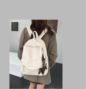 Vue détaillée du dos d'un sac à dos minimaliste en cuir PU crème avec pendentif teckel