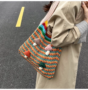 Detail of rainbow crochet tote bag featuring 3D mushroom accents and wavy knit texture