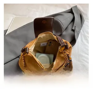 Interior view of brown suede quilted bag showing gold chain strap and daily essentials
