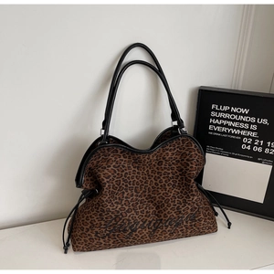Detail of leopard print tote bag featuring black embroidery and wavy leather trim edges