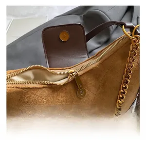Detail of brown quilted faux suede handbag with gold chain strap and magnetic closure