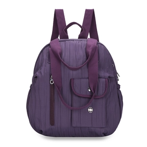 Detail of purple pleated nylon backpack featuring a metal logo and multi-pocket structure
