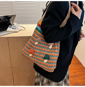 Detail of colorful crochet tote bag with 3D mushroom patches and striped knit texture