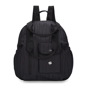 Detail of black pleated fabric backpack featuring a top handle and silver circular logo