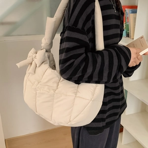 Détail du sac à main matelassé crème avec nœud décoratif et bandoulière à nœuds élégante