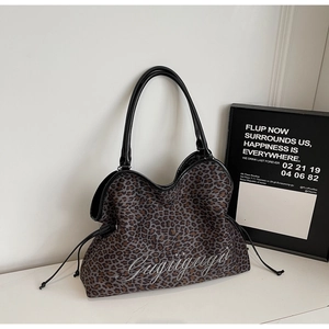 Detail of leopard print tote bag with silver Gugigugu embroidery and black leather handles