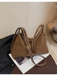 Detailed close-up of retro brown matte leather tote bag with vintage golden metal buckle