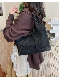 Detail of vintage matte black tote with VYGONGZHU logo and side drawstring design
