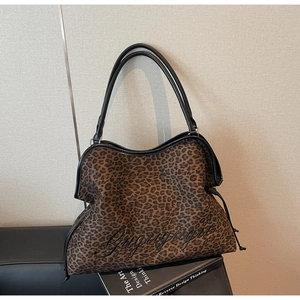 Detail of leopard print tote bag with black cursive embroidery and drawstring side