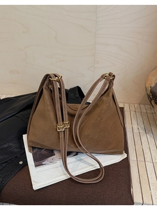 Detail shot of vintage brown leather tote bag with gold metal buckles and fine texture