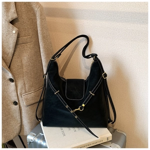 Detail of black faux leather hobo bag featuring white contrast stitching and gold buckle